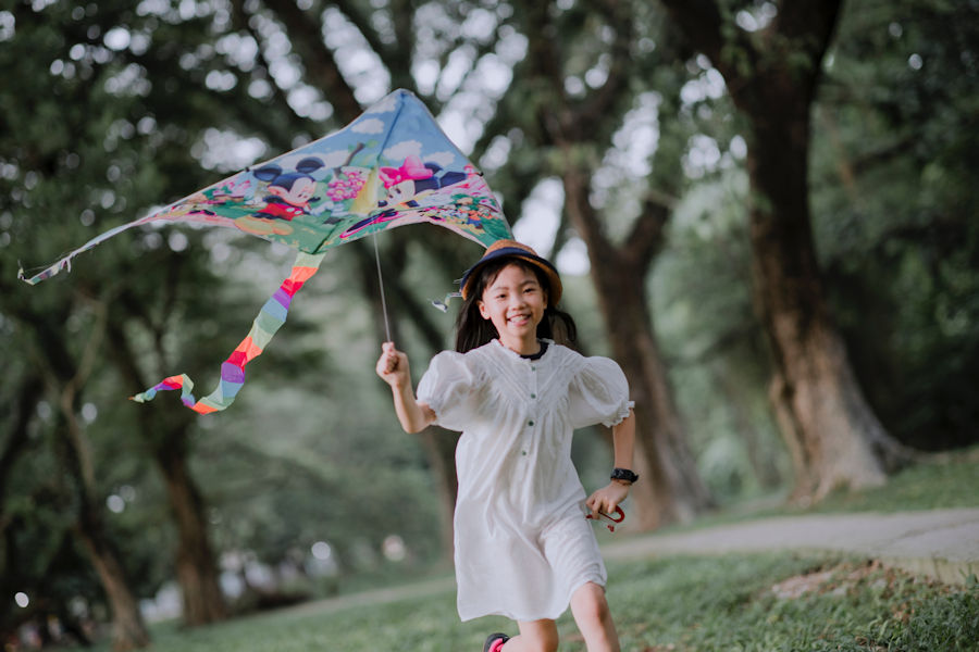Girl flying a kite in a park
